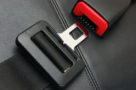 A seat belt being buckled. Driving safely goes a long way in avoiding accidents.